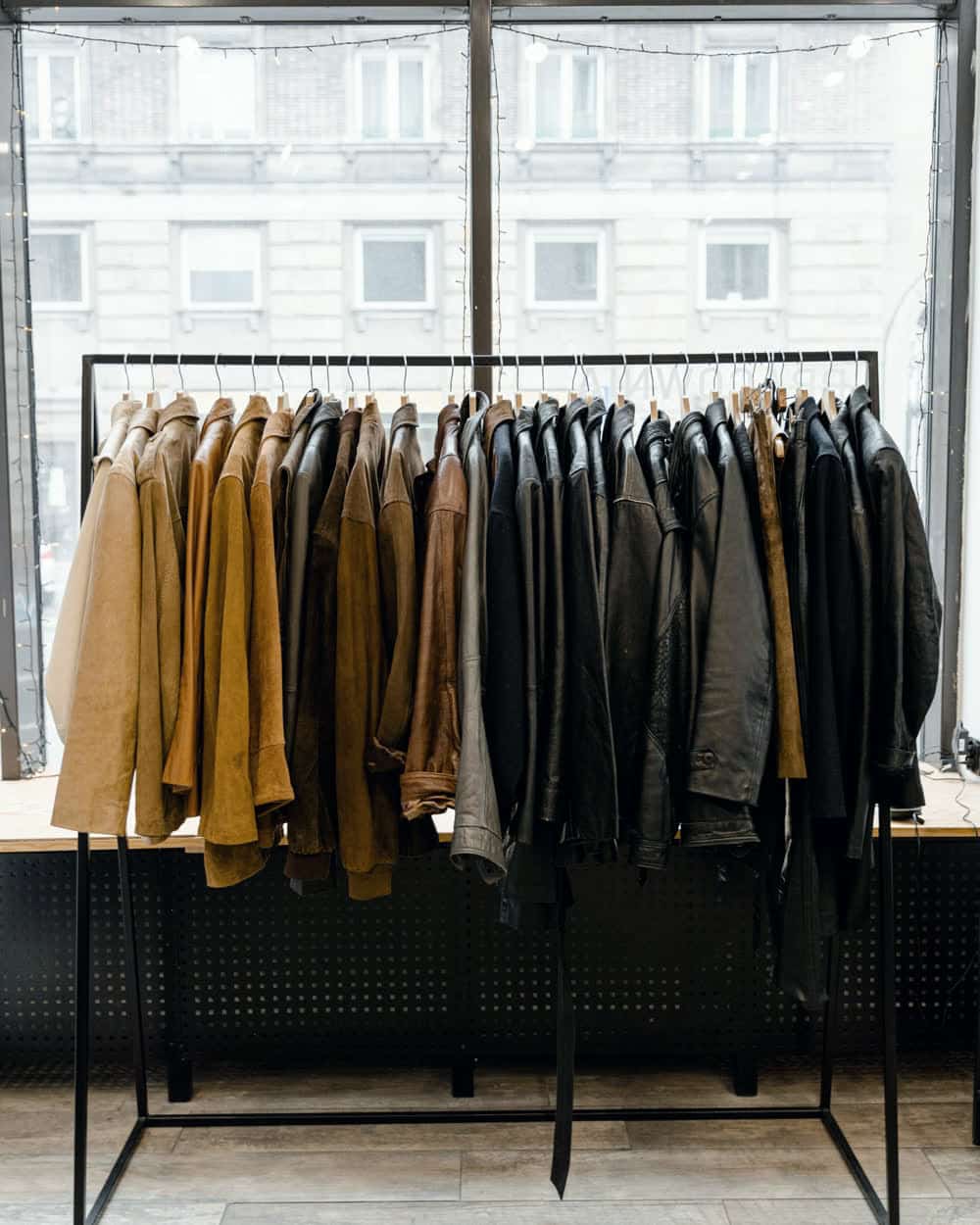 Men's jackets crowded along a shop rail, tan and brown through to black