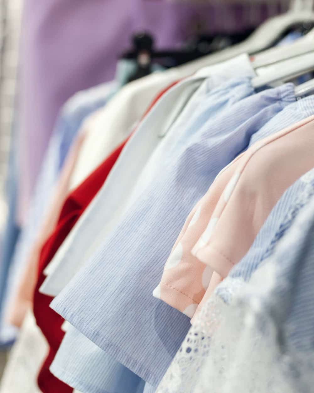 Women's tops on hangers in pale blue, pink, red and white