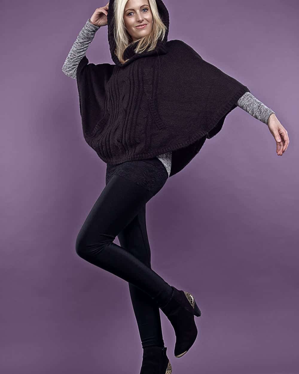A hooded knitted poncho in dark brown, cable-panelled at the front