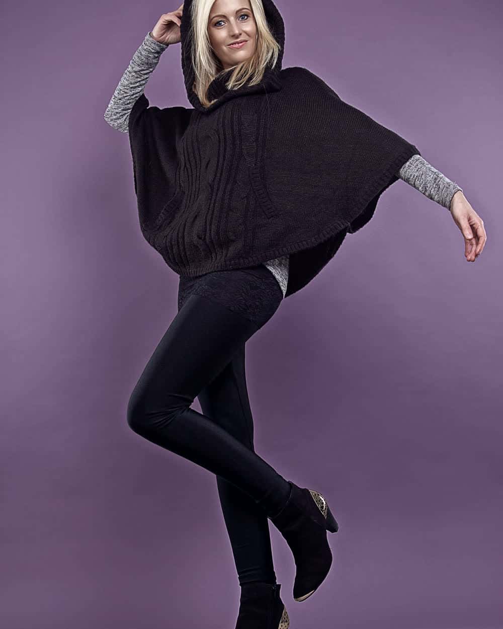 A hooded knitted poncho in dark brown, cable-panelled at the front